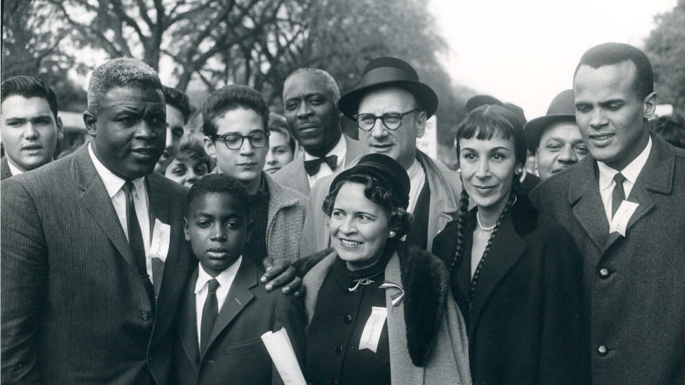 Baseball-Spieler Jackie Robinson (links) und Sänger Harry Belafonte (rechts) mit seiner Frau Julie unter den Demonstranten für die Aufhebung der Rassentrennung an Schulen am 25.10.1958 in Washington D.C.