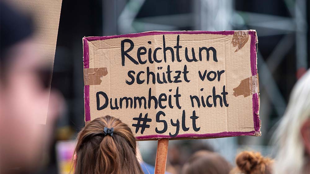 Eine Teilnehmerin auf einer Demo in Essen zeigt, was sie vom Sylt-Skandal hält