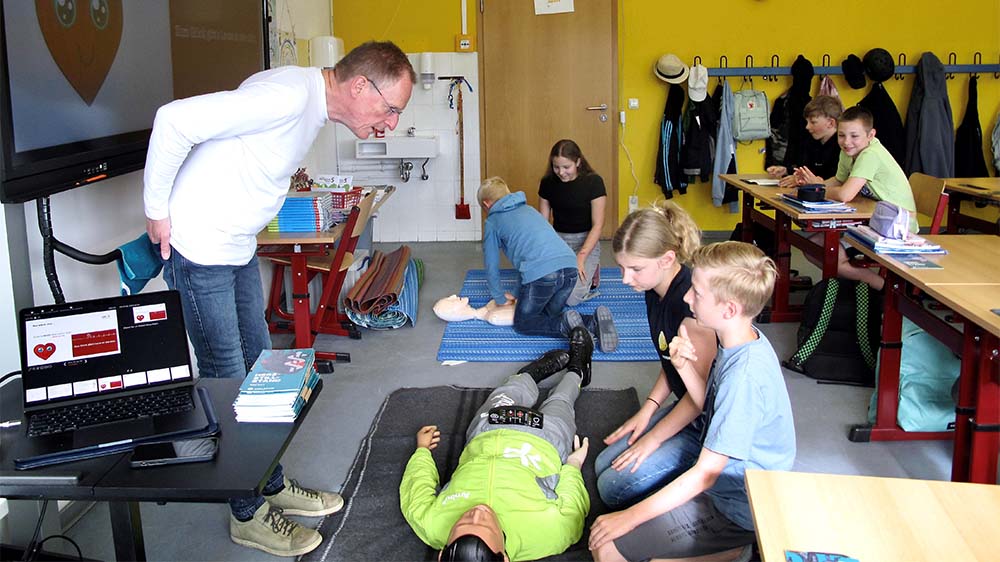 Der Notfallmediziner Bernd Müllejans übt mit den Fünftklässlern der evangelischen Schule St. Nikolai in Pasewalk an einer lebensechten Puppe eine Herz-Lungen-Massage