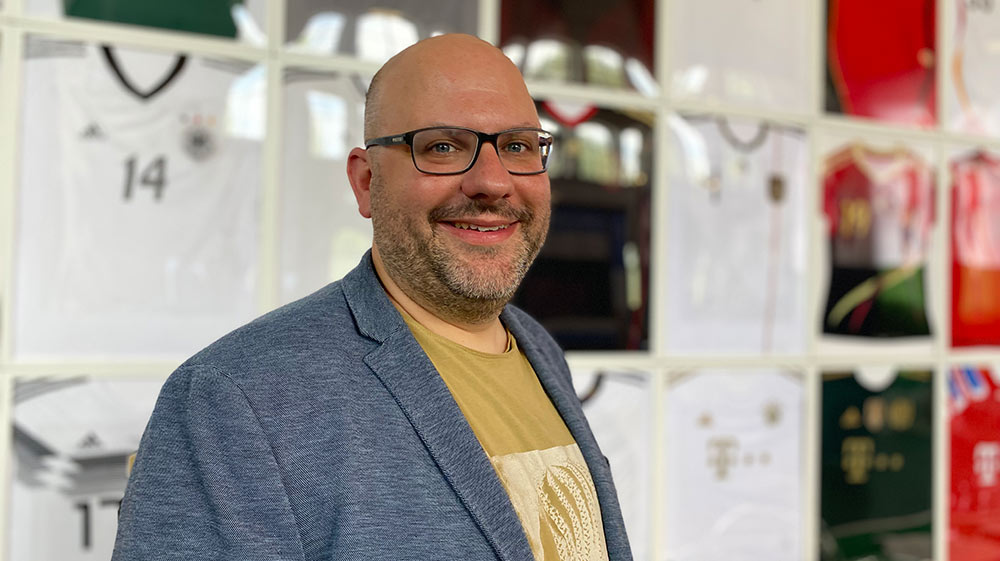 Der Kurator Torben Knye vor der Trikotwand im Auswanderermuseum.