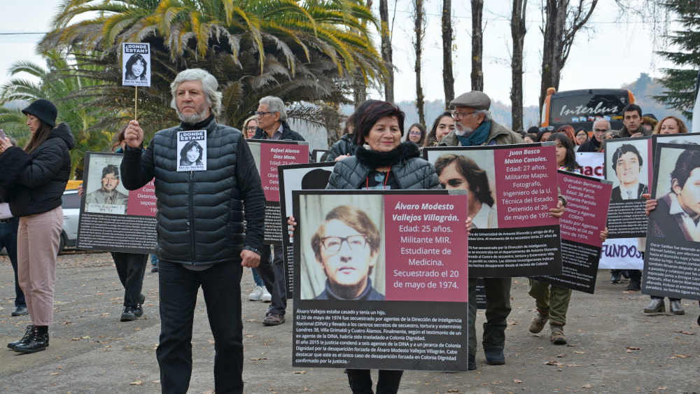 Protestmarsch mit Fotos von Menschen die in Colonia Dignidad (Chile) festgenommen, gefoltert und ermordet wurden