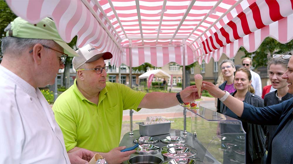 Der 45-jaehrige Patrick Salomon (2.l.) verkauft Eis der Eismeierei Babelsberg