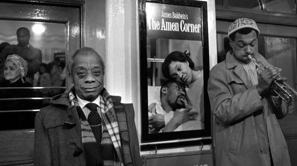 Der amerikanische Schriftsteller James Baldwin (links) vor einem Plakat zu einer Aufführung seines Dramas "The Amen Corner"