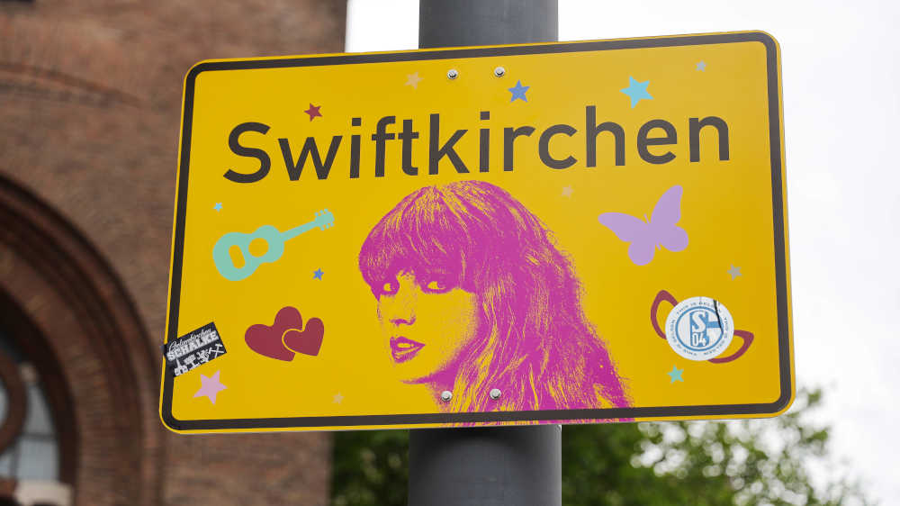 Ein Schild mit der Aufschrift "Swiftkirchen" mit Konterfei der Sängerin Taylor Swift