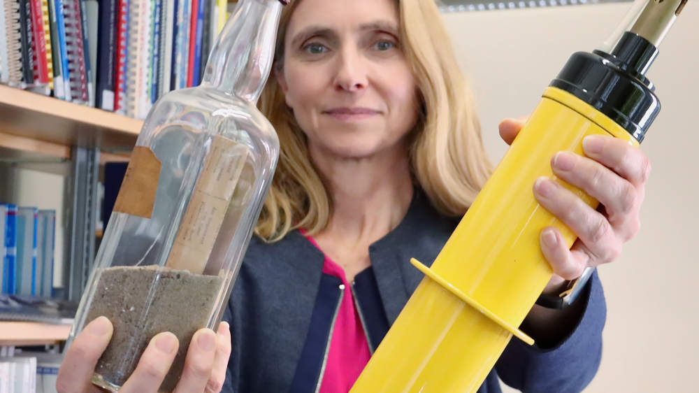 Bibliothekarin Martina Plettendorff zeigt eine alte Flaschenpost und das gelbe Modell der modernen Argo-Floats
