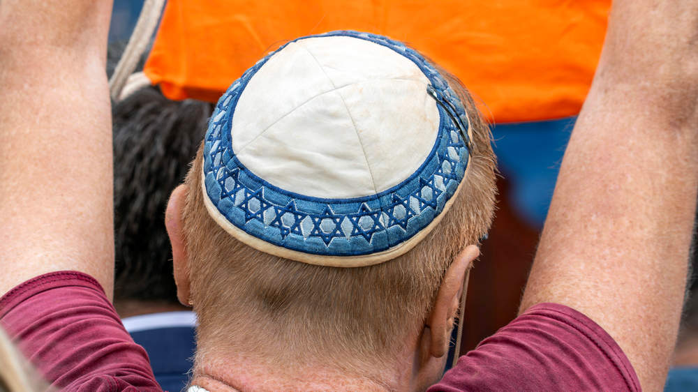 Während einer Solidaritäts-Demonstration mit Israel in München trägt ein Teilnehmer seine Kippa