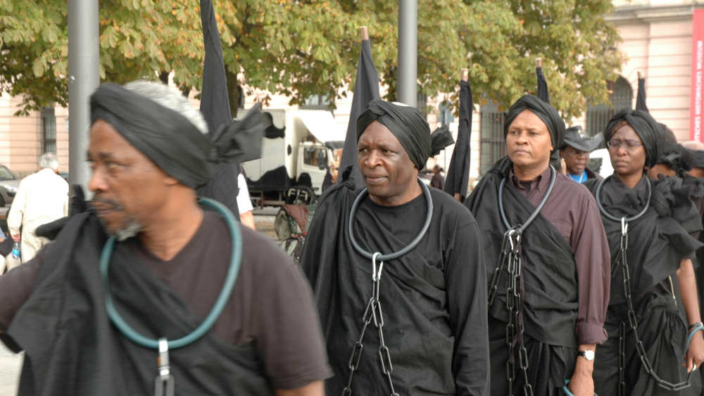 Angekettete Afrikaner präsentieren eine Performance in Berlin-Mitte zum Gedenken an den Maji Maji Aufstand gegen den deutschen Kolonialismus 1905 im heutigen Tansania (Archivbild vom 1.10.2006)