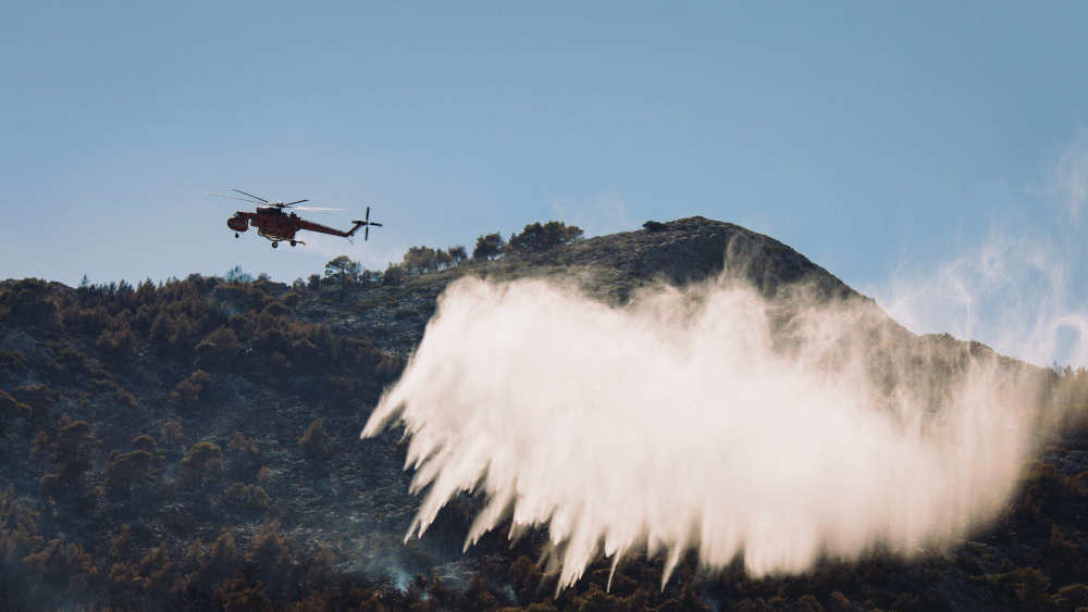 Ein Löschhubschrauber ist im Einsatz, um die Flammen nach dem Brand zu löschen, der am 11. August 2024 in Athen, Griechenland, in der Gegend von Nea Makri ausbrach
