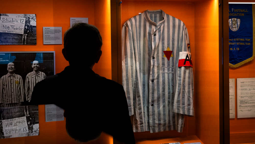 Ein ehemaliger KZ-Haeftling aus Polen laesst sich nach 1945 die KZ-Haeftlings-Uniform nachschneidern, um sie an Gedenkfeiern zu tragen