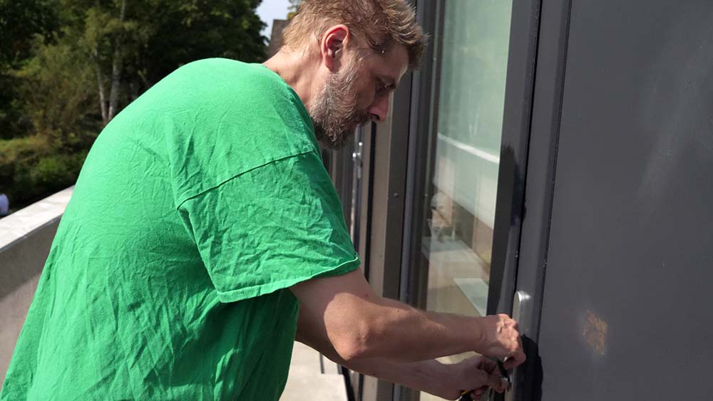 Timo schließt die Tür zu seinem Mikro-Apartment auf