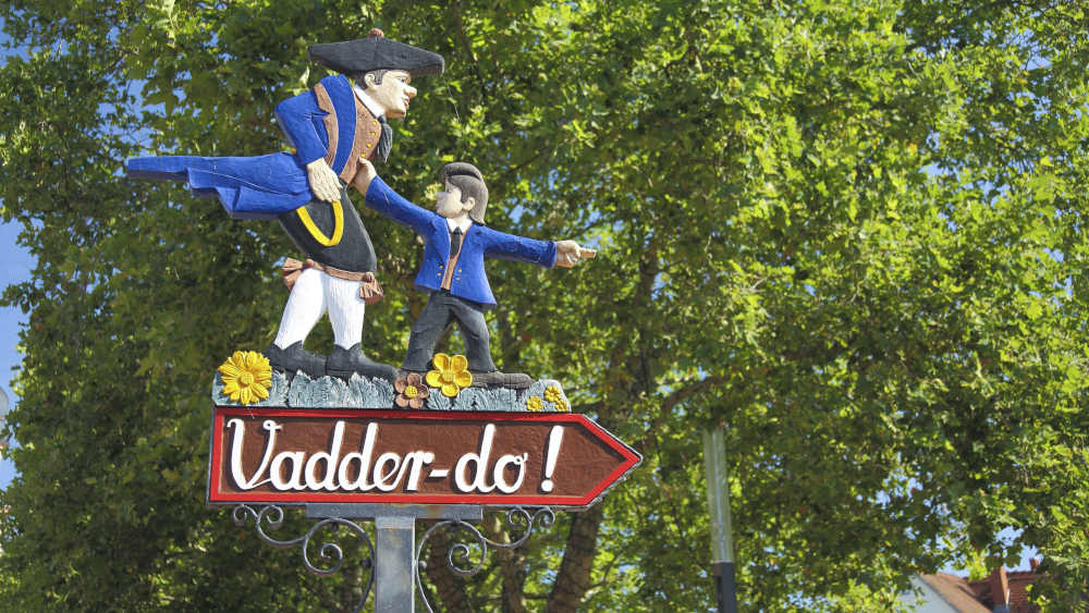 Hinweisschild mit Figuren und Inschrift Vadder-do im hessischem Dialekt