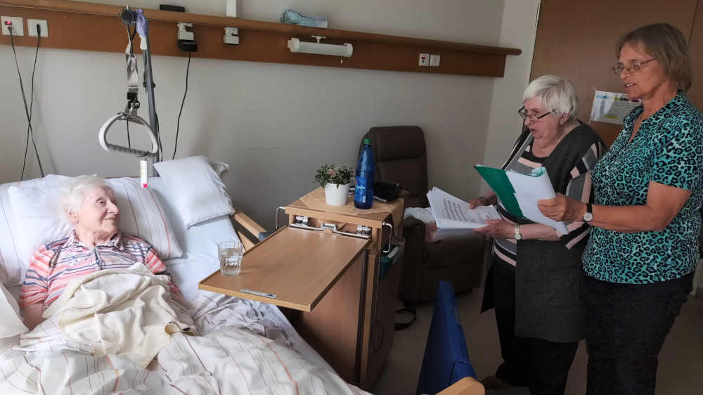 Die Abendsängerinnen Gabriele Blum-Eisenhardt (re.) und Anne Krei (M) singen mit einer Bewohnerin eines Seniorenzentrums