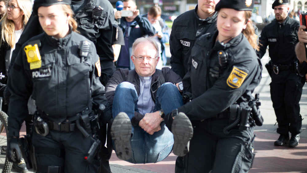 Klima-Aktivist und Jesuitenpater Jörg Alt wird nach einer Straßenblockade von der Polizei abtransportiert (Archiv)