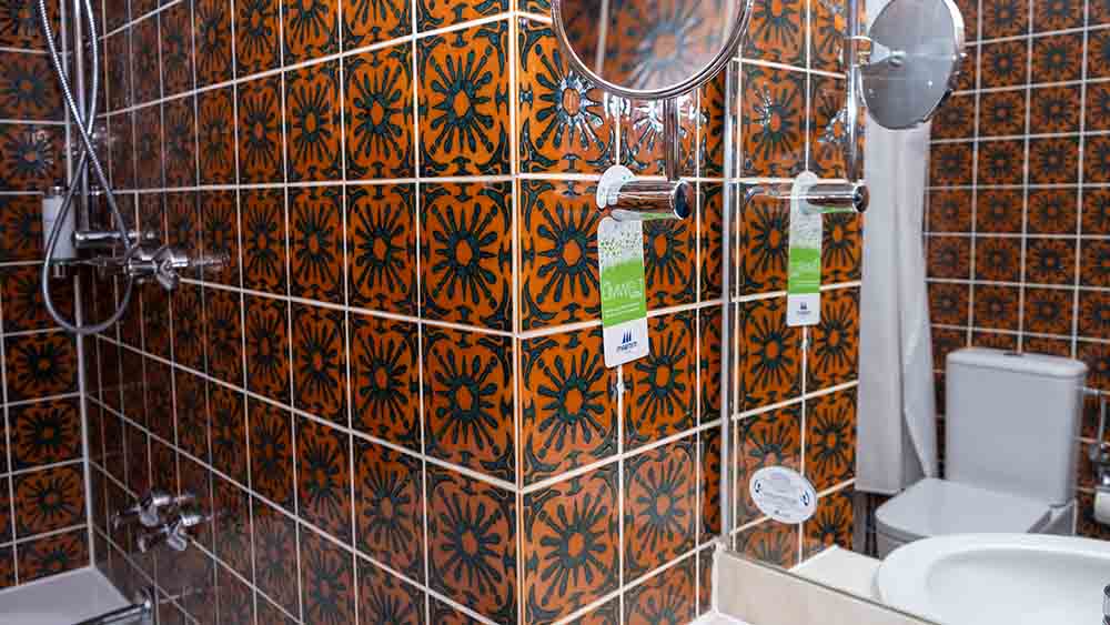 Nicht jedermanns Sache: Das Bad der denkmalgeschützten Zimmer hat Fließen in einem knalligen Orange