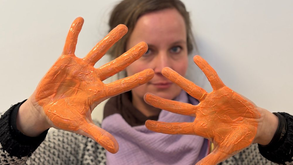 Auch unsere Redaktion setzt ein deutliches Zeichen. Mit orangefarbenen Händen protestieren wir gegen Gewalt an Frauen. 