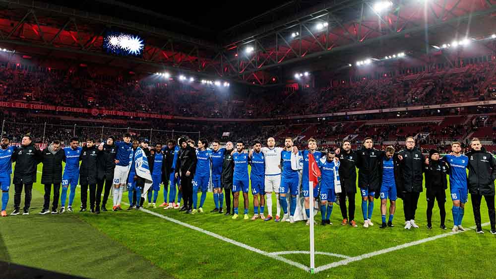 Nach dem Spiel in Düsseldorf halten die Spieler des 1. FC Magdeburg gemeinsam mit den Fans inne