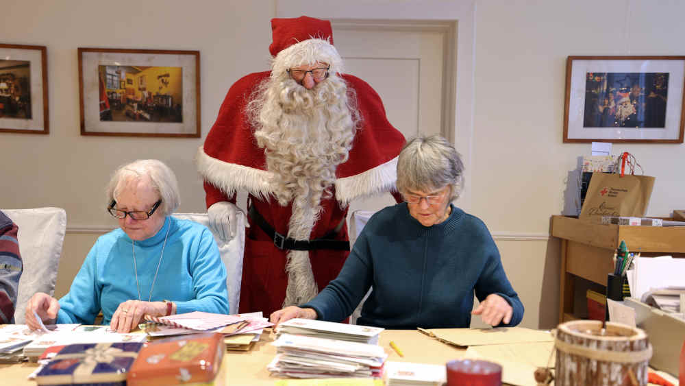 Mitarbeiter vom Weihnachtsmann sortieren Briefe aus aller Welt
