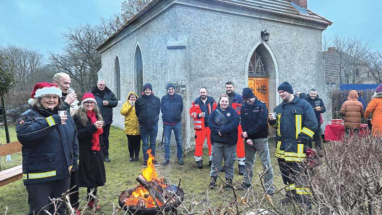 Mitglieder des Vereins "Blaulichtkirche" am Lagerfeuer am 2. Advent vor der Kapelle in Ganz