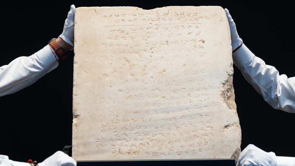 Mitarbeiter des Auktionshauses Sotheby's präsentieren die Steintafel vor der Versteigerung