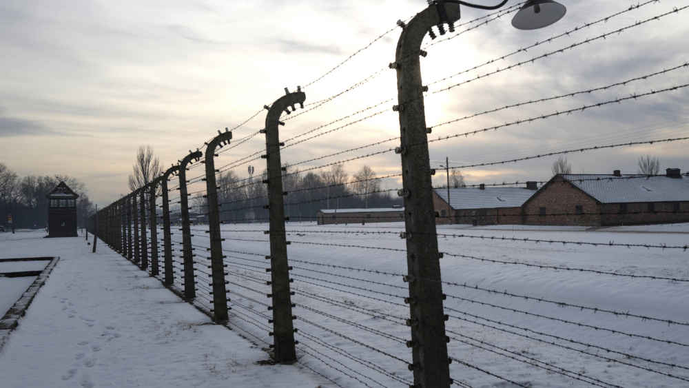 Blick auf den Zaun und die Baracken des Lagers Auschwitz Birkenau