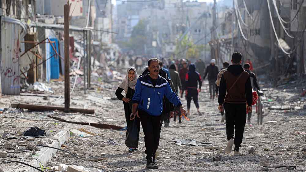 Nach Beginn der Waffenruhe laufen die Menschen durch zerstörte Straßen im Gazastreifen