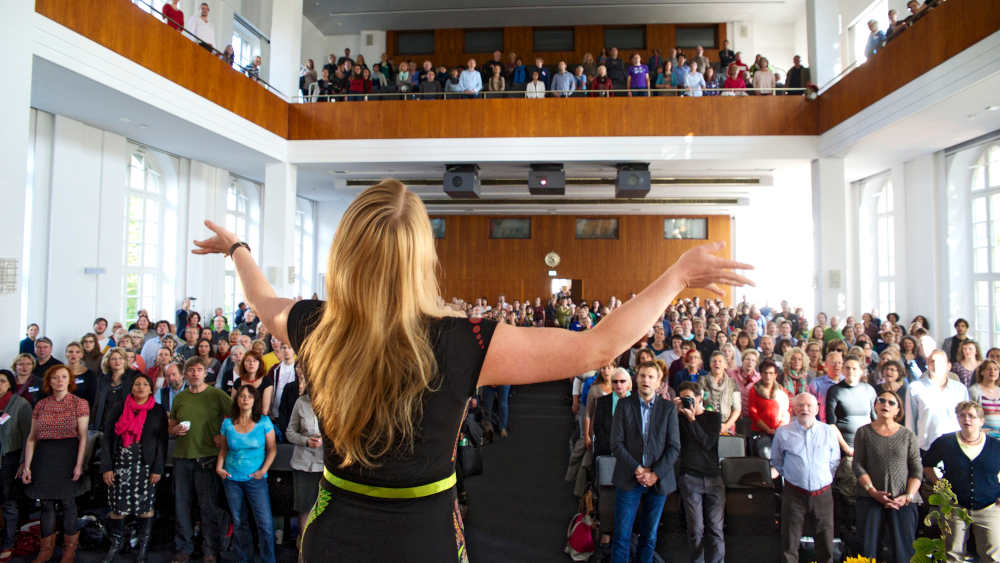 Johanna Seiler, Coach für Stimmentfaltung und Vokal-Improvisation, leitet ein gemeinsames improvisiertes Singen in der Humboldt Universität in Berlin (Archivbild 2013)