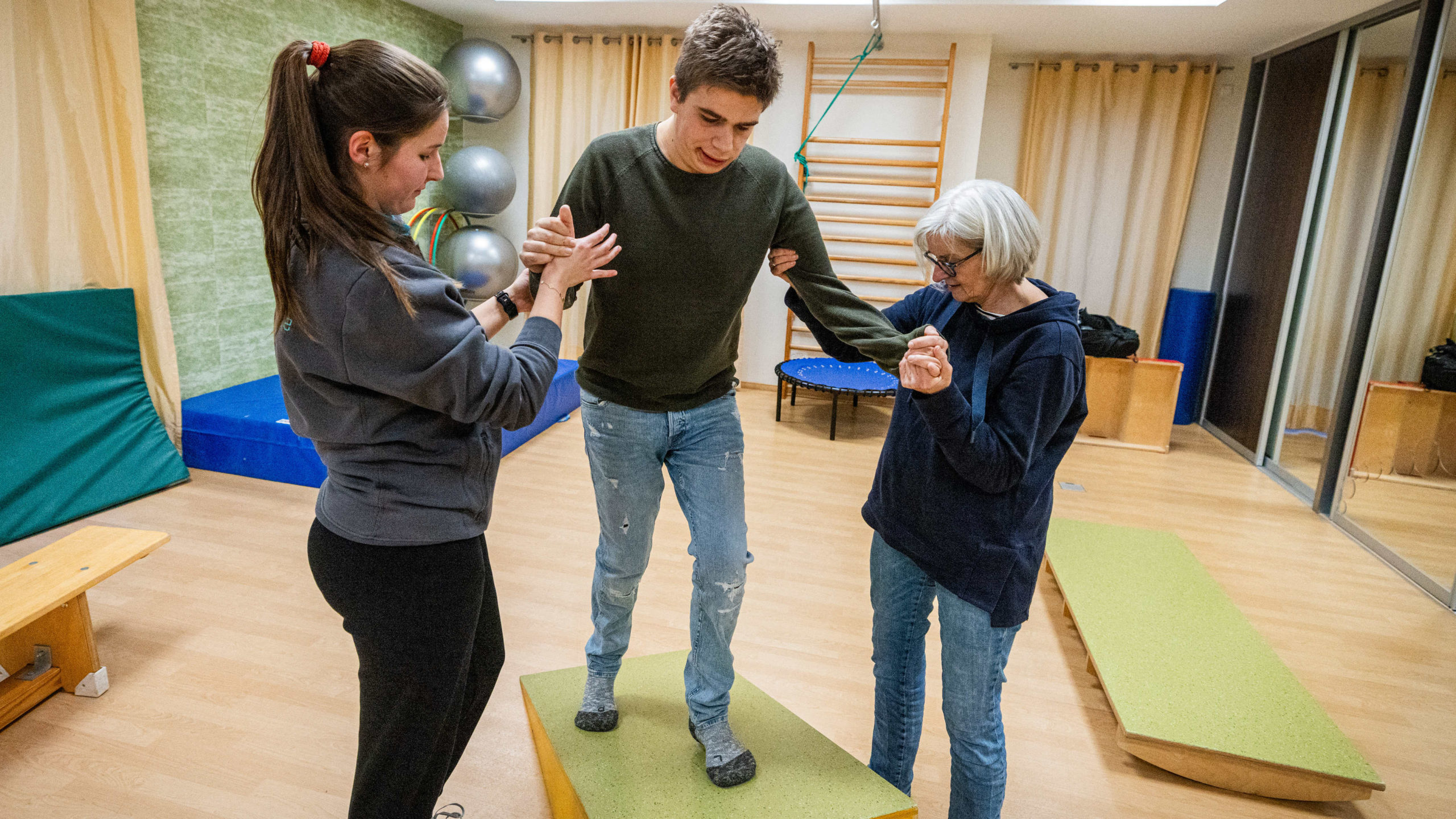 Erik Siemeister mit seiner ehrenamtlichen Begleiterin Martina Strathmann (re.) und Therapeutin Alexandra bei der Physiotherapie