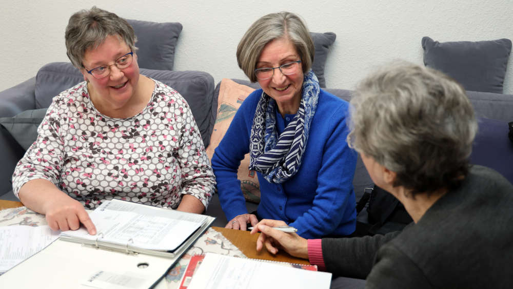 Caritas-Sozialarbeiterin Gabriele Kleine-Kuhlmann (li.) und Maritta Zehnich-Rautmann (M.) vom Bremer Modellprojekt Organisationsassistenz" unterstützen Menschen bei Behördensachen