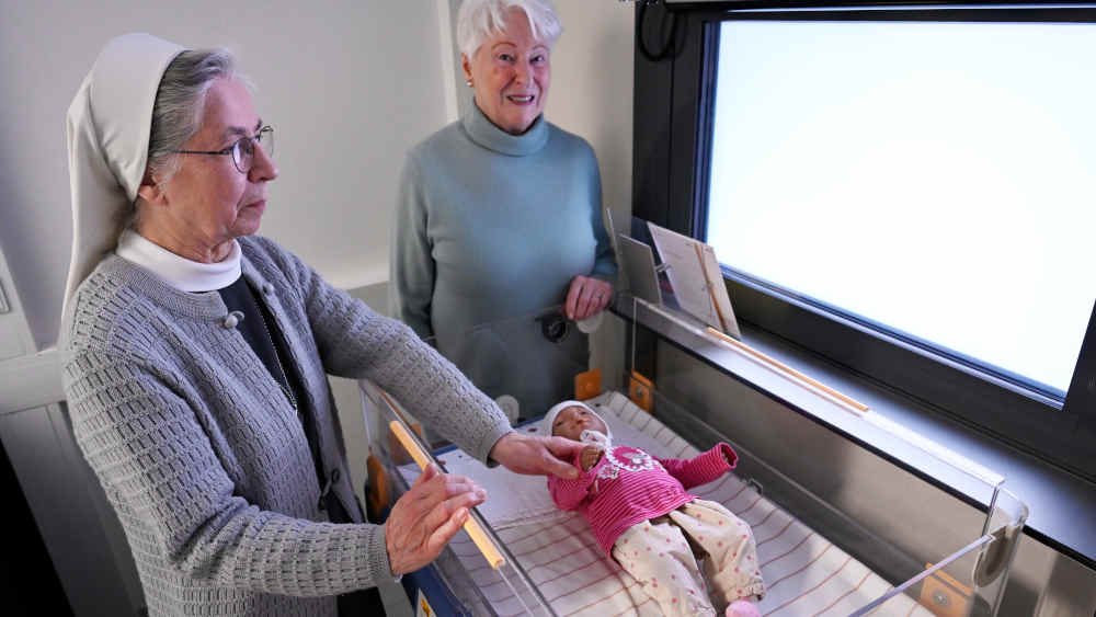 Schwester Annette Biecker (li.)und Marion Meister (re.), vom Sozialdienst Katholischer Frauen, mit einer Puppe an der Babyklappe am St. Vinzenz-Krankenhaus