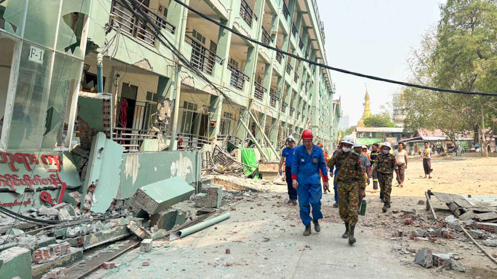 Rettungskräfte während einer Such- und Rettungsaktion an den Ruinen eines Gebäudes in Myanmar