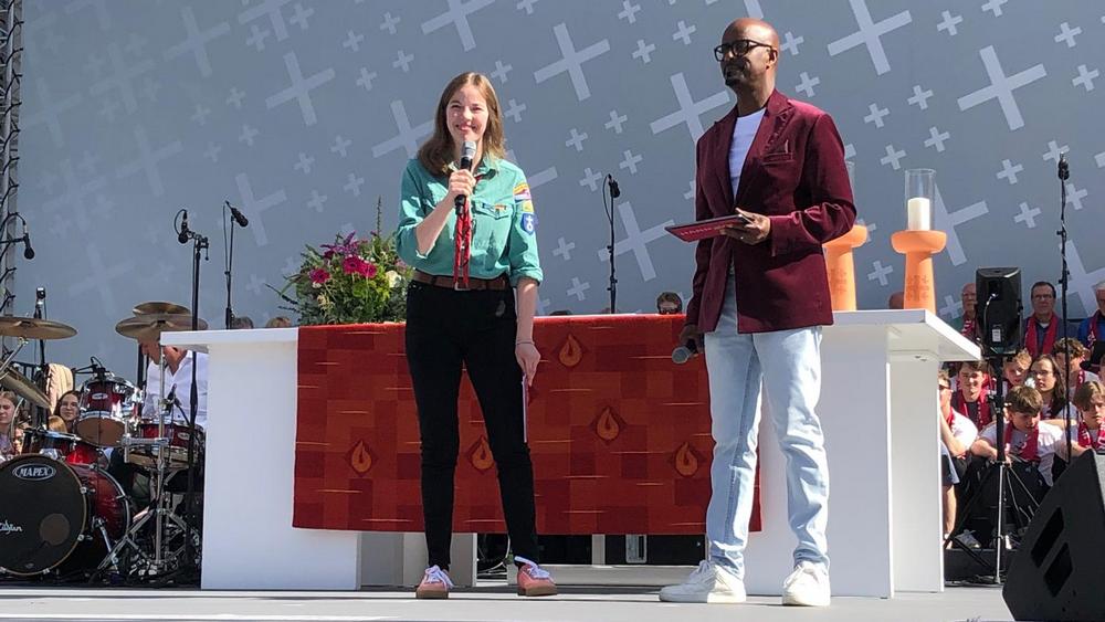 Pfadfinderin Karen Münster und NDR-Moderator Yared Dibaba beim Warmup für den Eröffnungsgottesdienst
