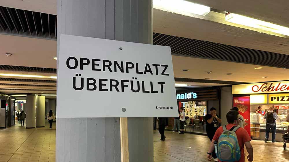 Das erste "Überfüllt"-Schild des Kirchentags - und der Kollege kommt nicht mehr rein