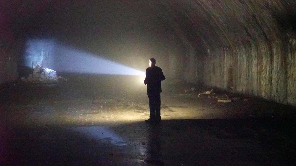 "Lost Places – Geheime Welten - Sowjetische Schatten": En Mann steht in einer Höhle und leuchtet mit einer Taschenlampe