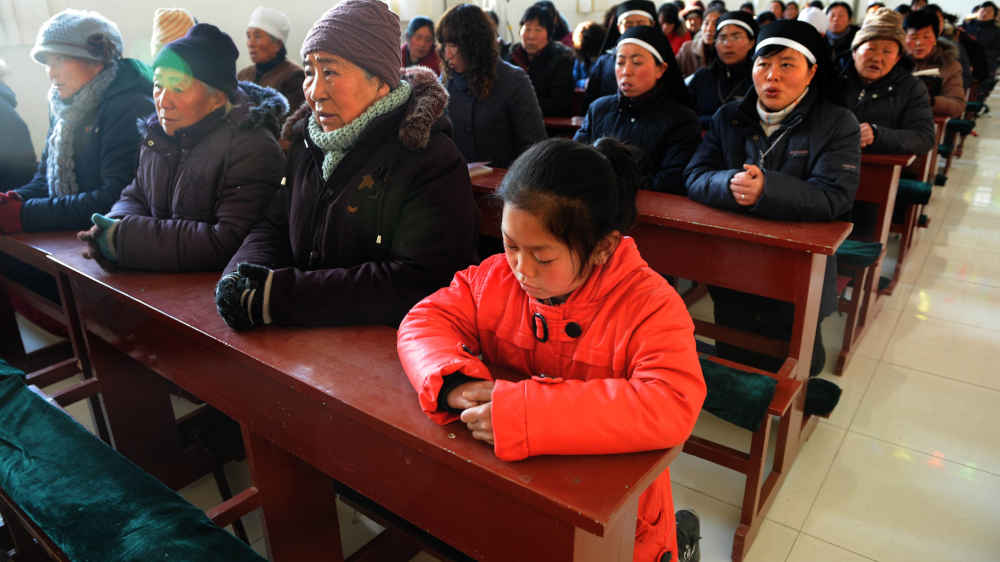 Katholische Dorfbewohner besuchen eine Sonntagsmesse in einer katholischen Kirche im Dorf Maotuan im Kreis Jingbian