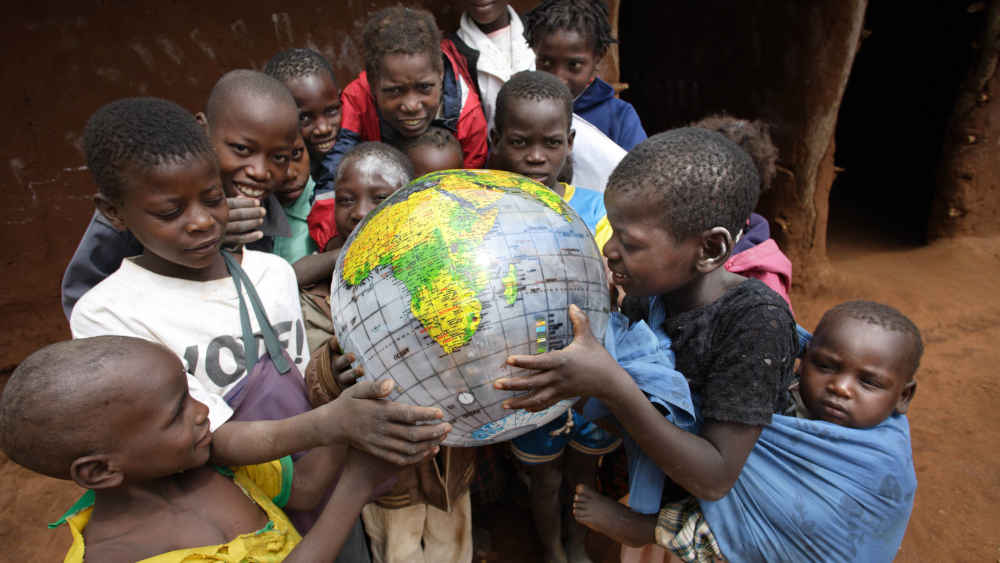 Schulkinder spielen mit einer Weltkugel (Symbolbild)