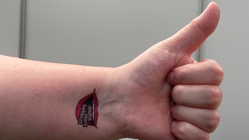 Daumen und Tattoo der Kollegin Nicole Schneider