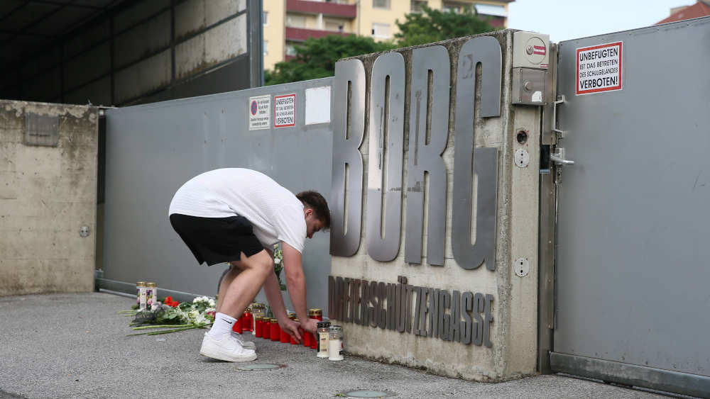 Bürger gedenken der Opfer, indem sie Blumen und Kerzen vor der Oberschule in Graz, Österreich, niederlegen, wo bei einem bewaffneten Angriff elf Menschen, darunter der Angreifer, und zwölf weitere starben