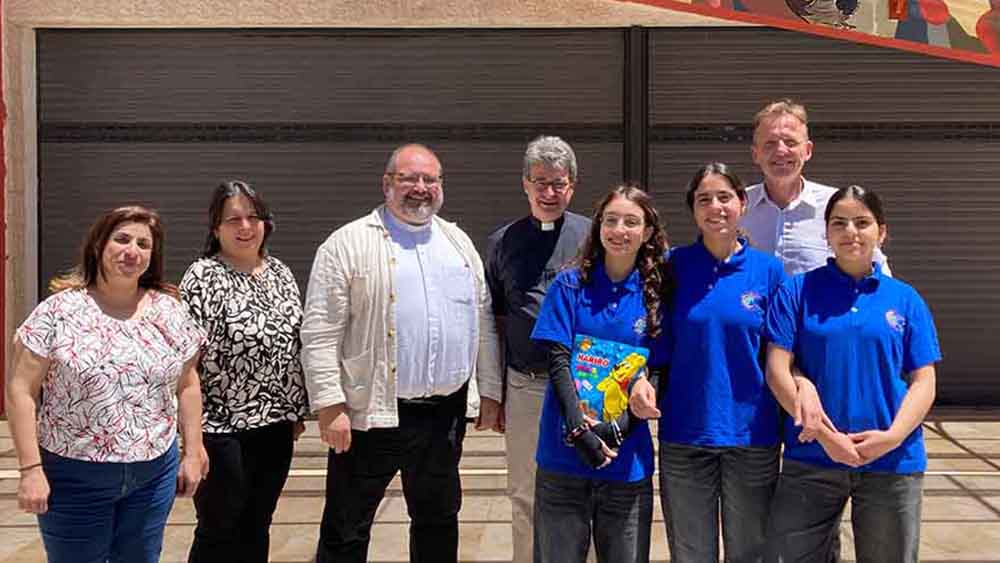 Gruppenfoto mit Schulleiter Birger Reese, Lehrerinnen und Schülerinnen der Schule Talitha Kumi bei einem Austausch über Bildung und Alltag in Palästina