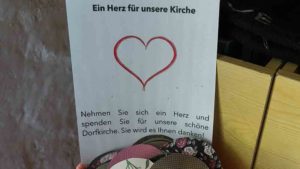 Ein Zettel mit einem Herz weist darauf hin, dass die Kirchengemeinde Spenden sammelt