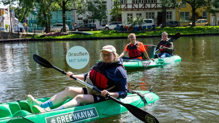 Unsere Redakteurin Rebekka Krüger probiert das Müllsammeln mit dem Kayak auf der Trave aus