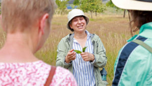 Frau klärt Gruppe über Heilpflanzen auf