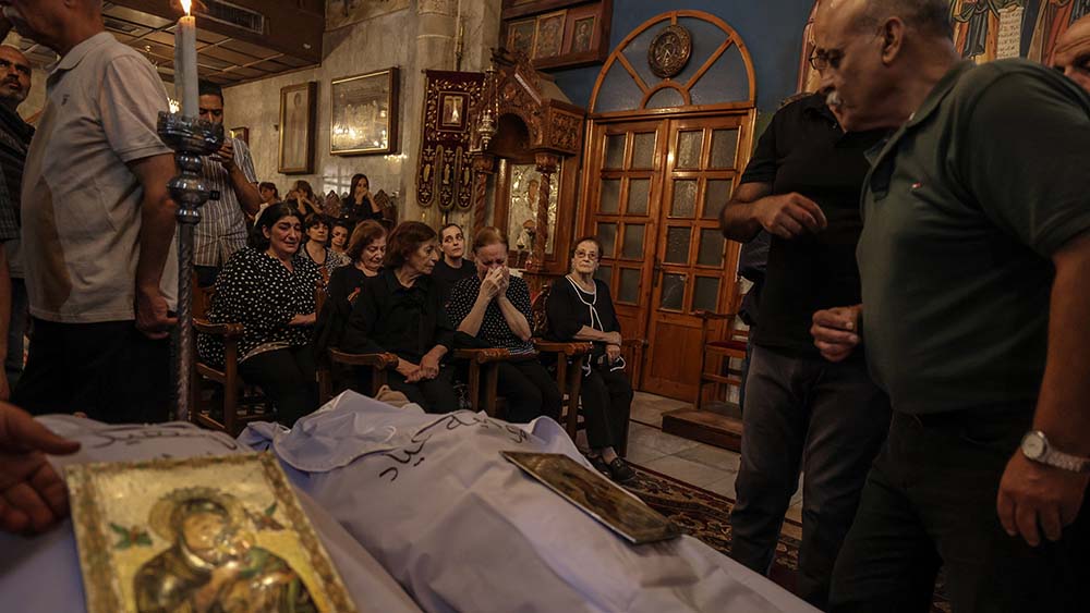 In einem Gottesdienst gedenken Angehörige den drei Menschen, die durch eine Granate auf die katholische Kirche in Gaza getötet wurden