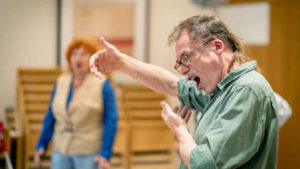 Mann singt mit erhobener Hand