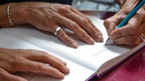 Frau schreibt einen Eintag in das Gästebuch