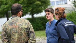 Junge Frau redet mit Angestellten der Bundeswehr