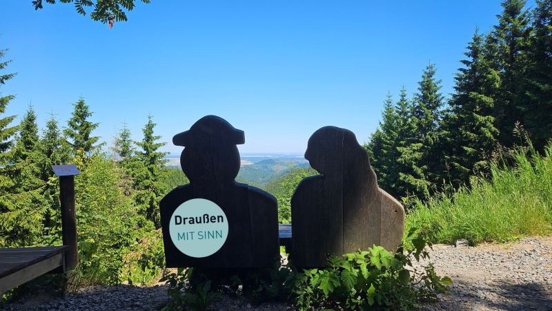 Die Sitzgelegenheiten am Wegesrand haben alle mit der Liebe zu tun – dieses Holzpaar hält Händchen