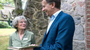 Frau und Mann stehen vor Kirche und lächeln sich an