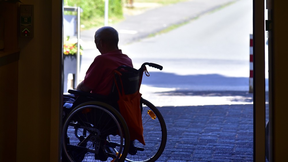 Ein Bewohner eines Seniorenheims sucht Schatten