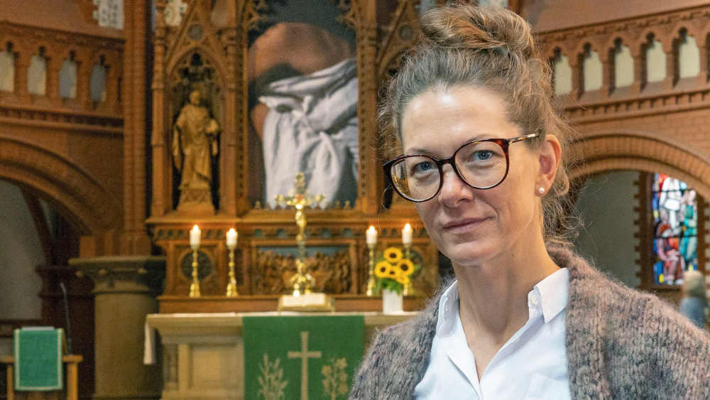 Die Künstlerin Julia Krahn vor der großformatigen Fotografie in der Dreifaltigkeitskirche in Hannover