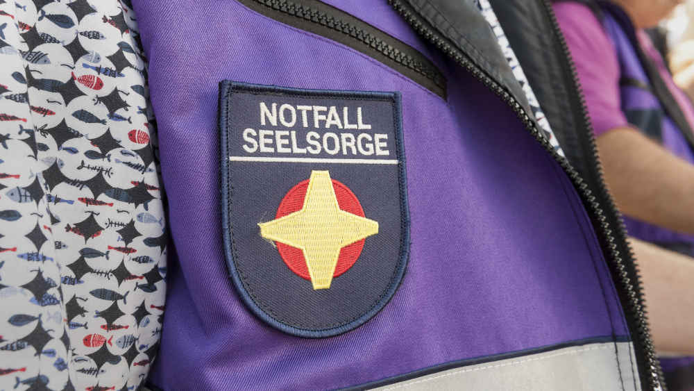 Zu erkennen sind Notfallseelsorger oft an ihren lilafarbenen Jacken mit dem gelben Kreuz auf rotem Grund